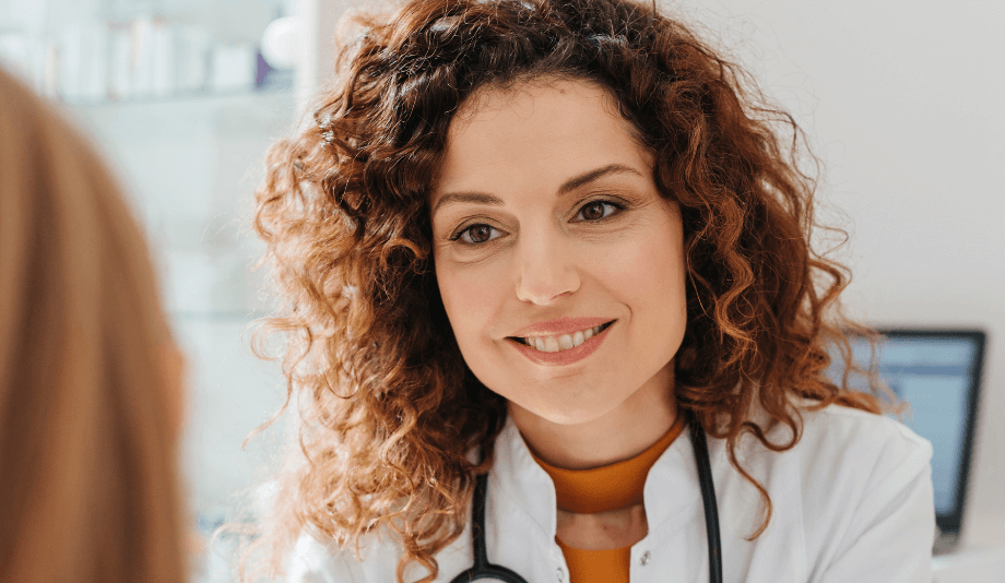 A smiling woman doctor examining a patient.