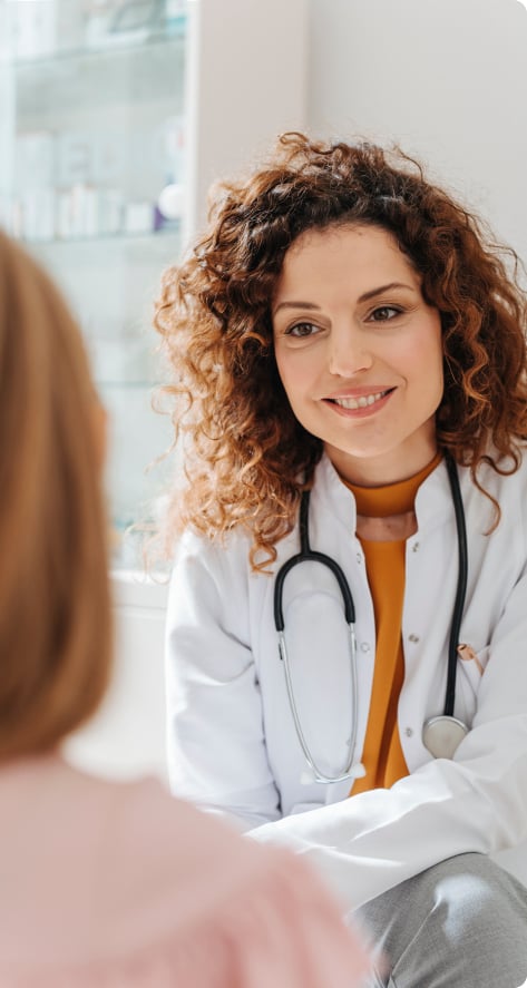 A smiling woman doctor examining a patient.